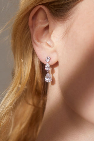 close up image of model wearing the chloe pear drop earrings.